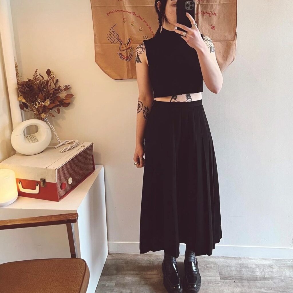 woman in long black skirt and black cropped sleeveless tee