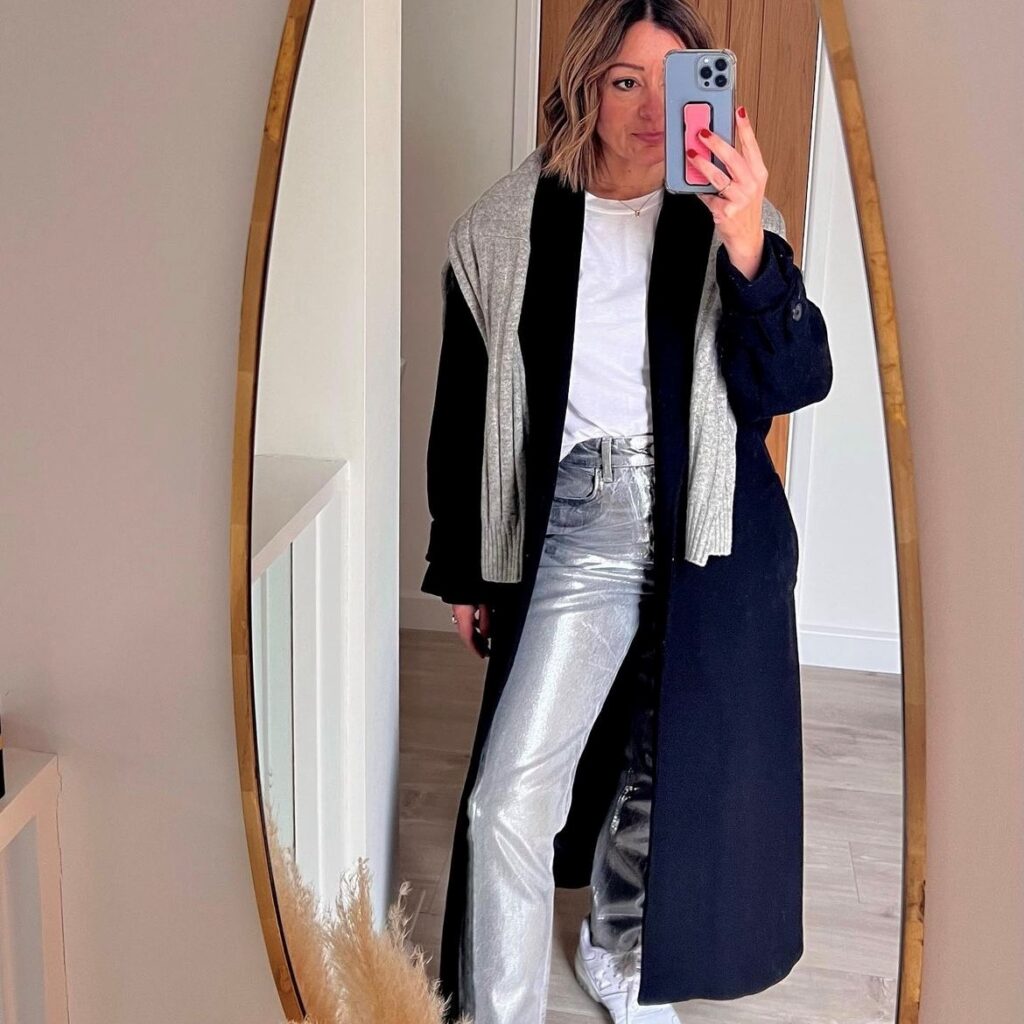 woman in metallic jeans, white t-shirt, and black trench coat