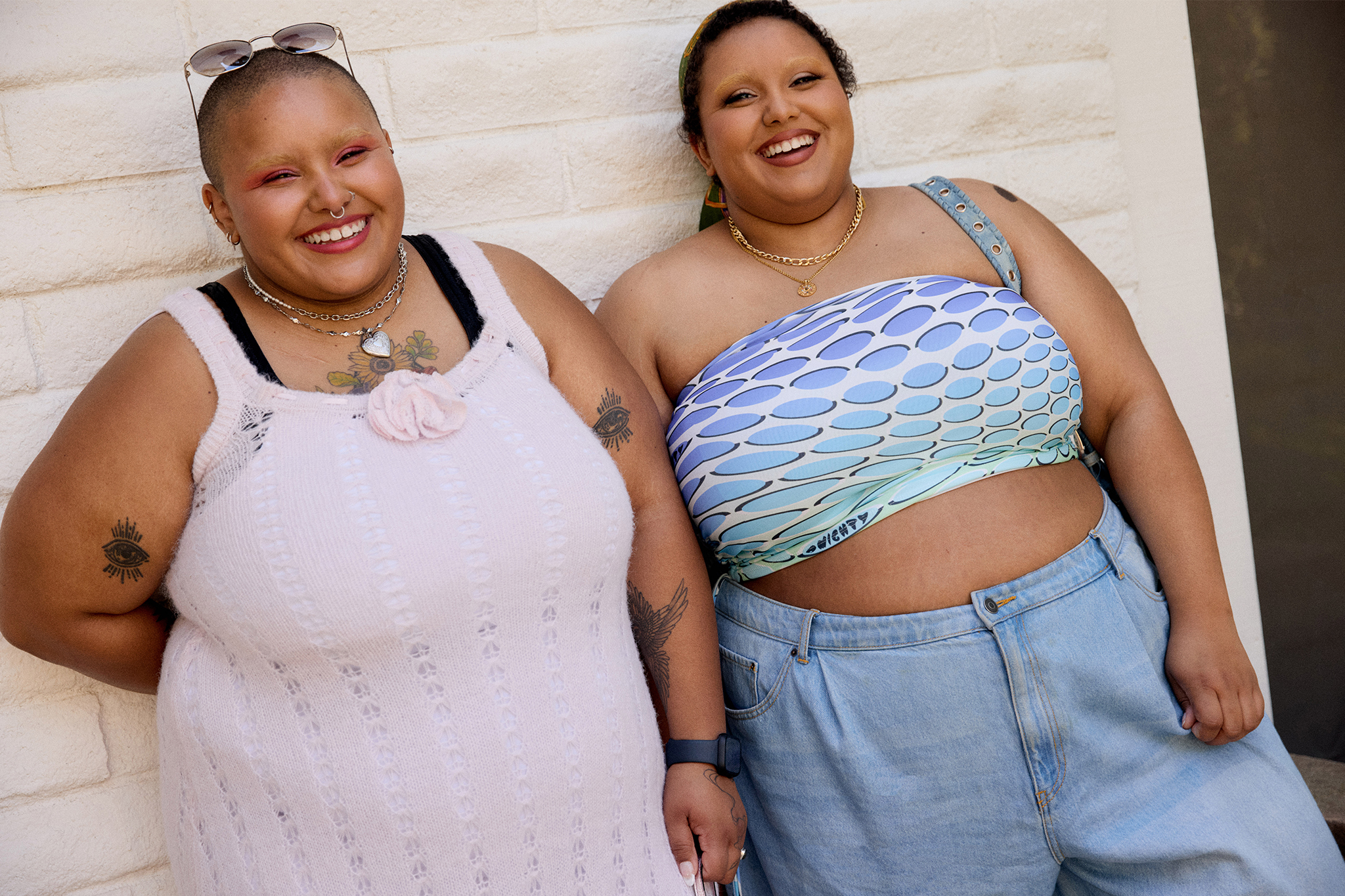 Tahra and Kyrah wearing summer fashion smiling leaning towards each other