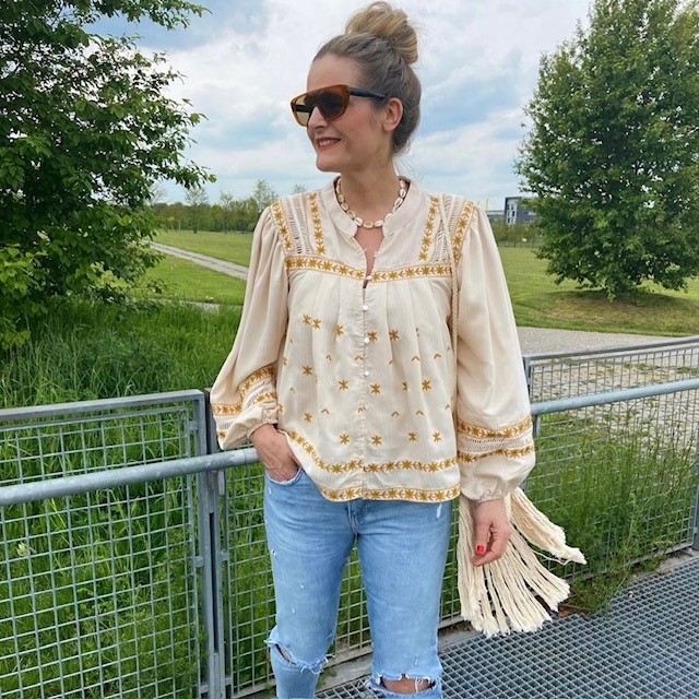 woman wearing a butter yellow top and distressed jeans