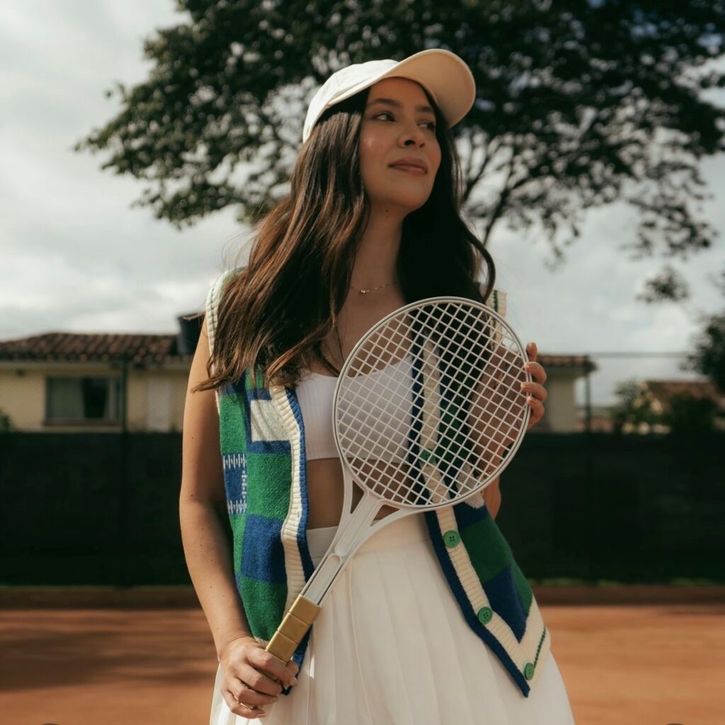 woman holding a tennis racket wearing tennis outfit