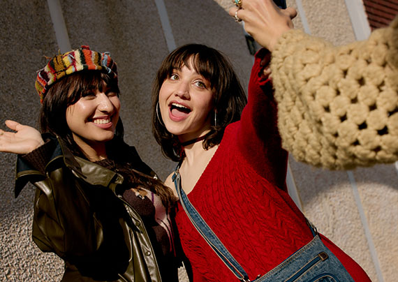 models wearing fall fashion posing for a cell phone camera