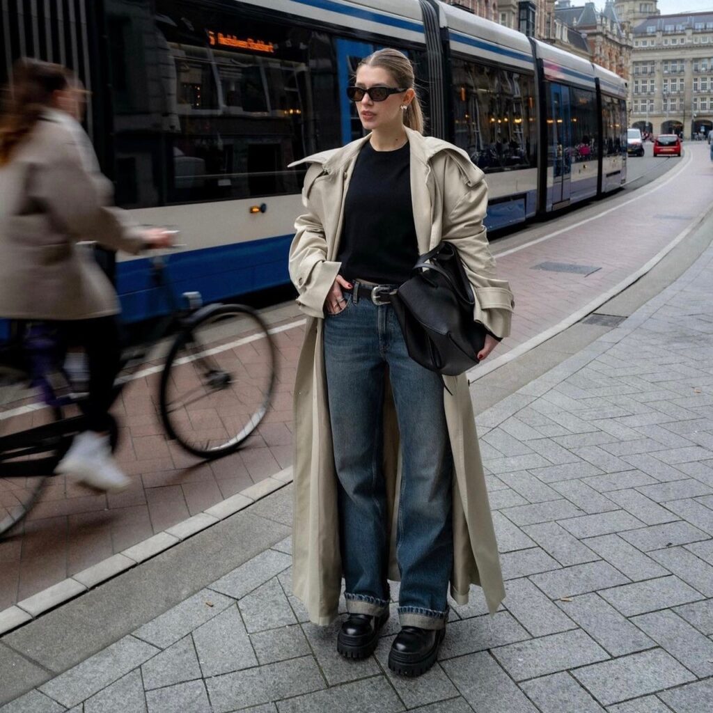 woman wearing a trench coat over jeans and a black t-shirt