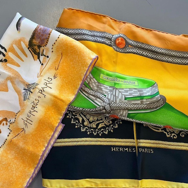 pile of folded Hermes scarves