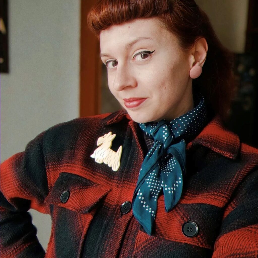 woman in red and black plaid jacket with blue neck scarf