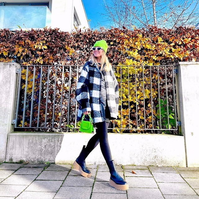 woman wearing on in black and wide plaid with neon green accessories