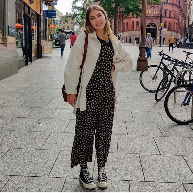 woman wearing one in black and yellow, with sneakers and a shirt jacket