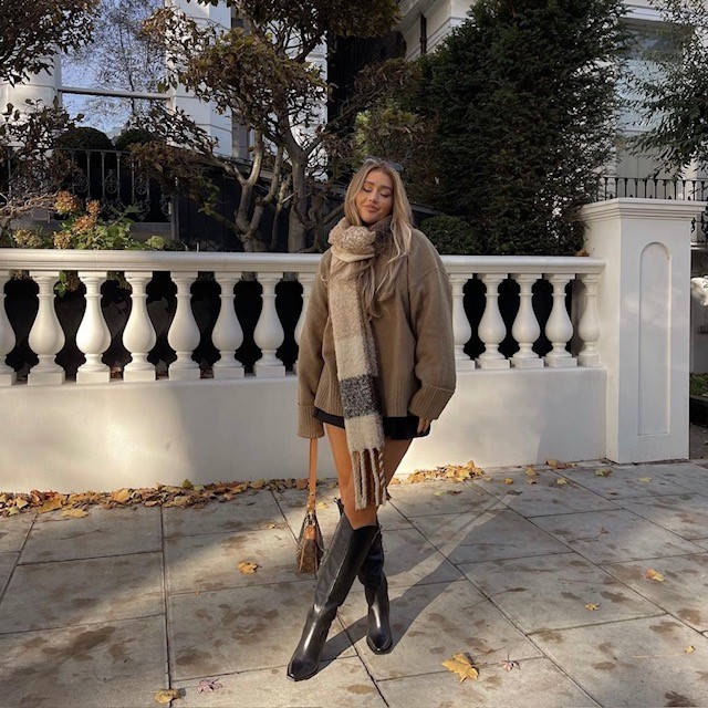 woman wearing black pair with shorts, oversized sweater, and big scarf