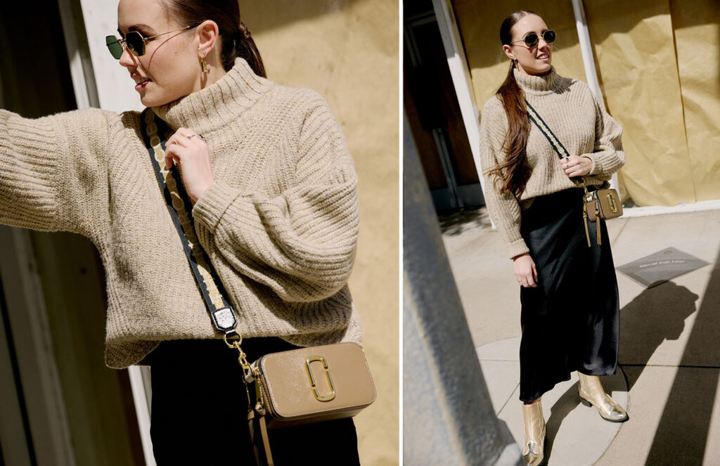 mallory wearing a beige sweater, marc jacobs side bag, and a black long skirt with gold boots