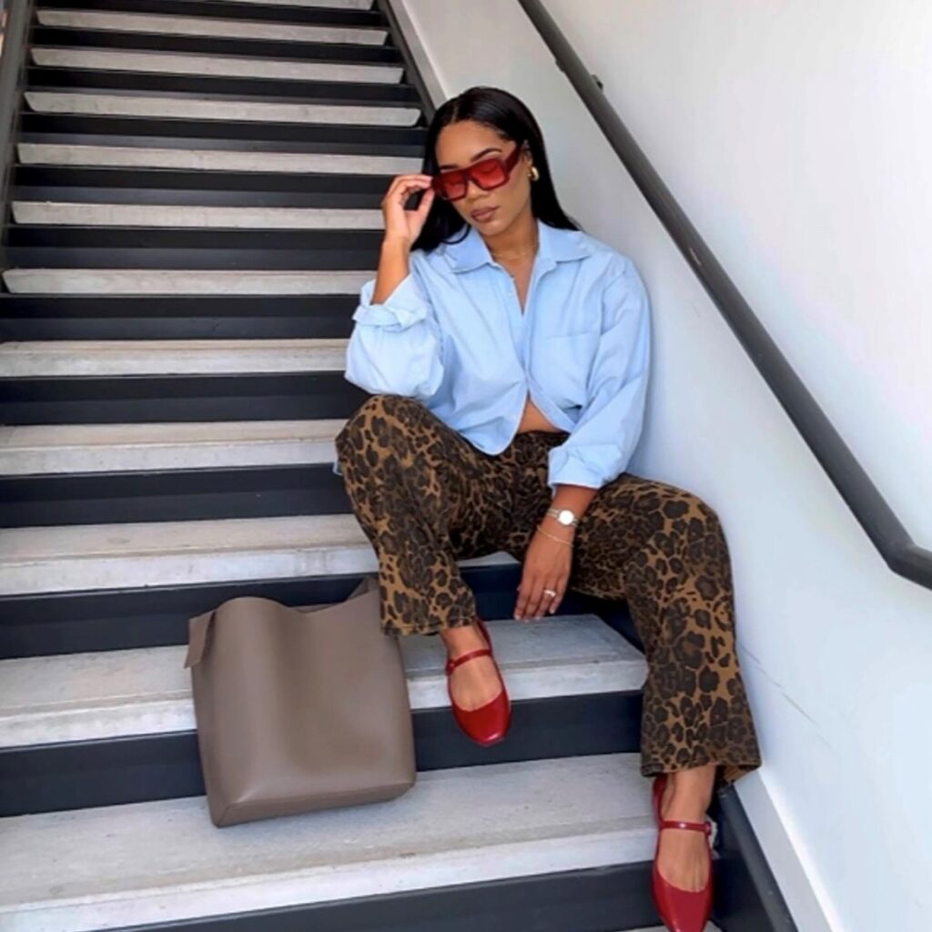 woman in leopard print pants with red heels and blue button-down