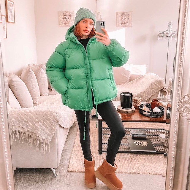 example of puffers: woman wearing a green puffer jacket with leggings