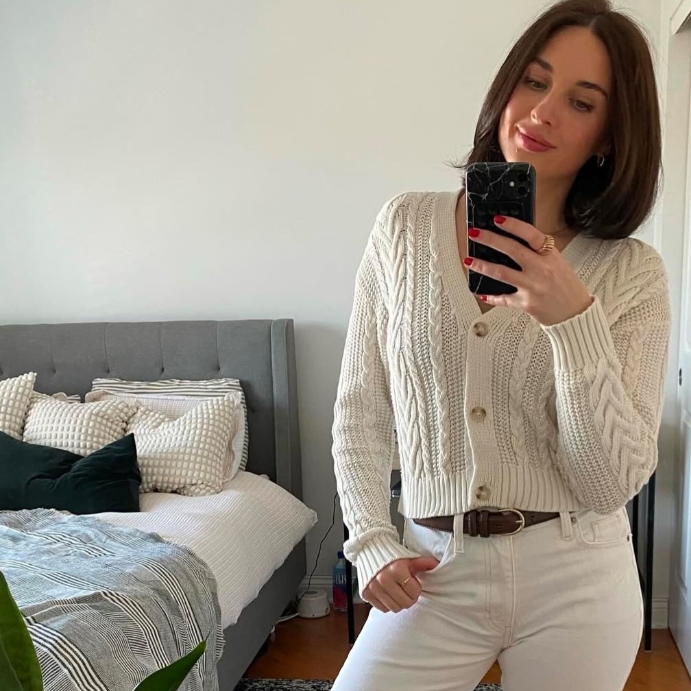 woman in an off-white cardigan with jeans