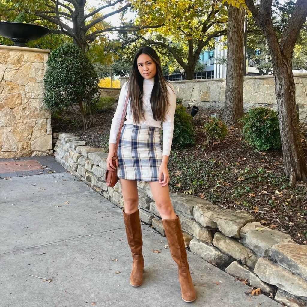 woman with turtleneck sweater, plaid mini and tall brown suede boots