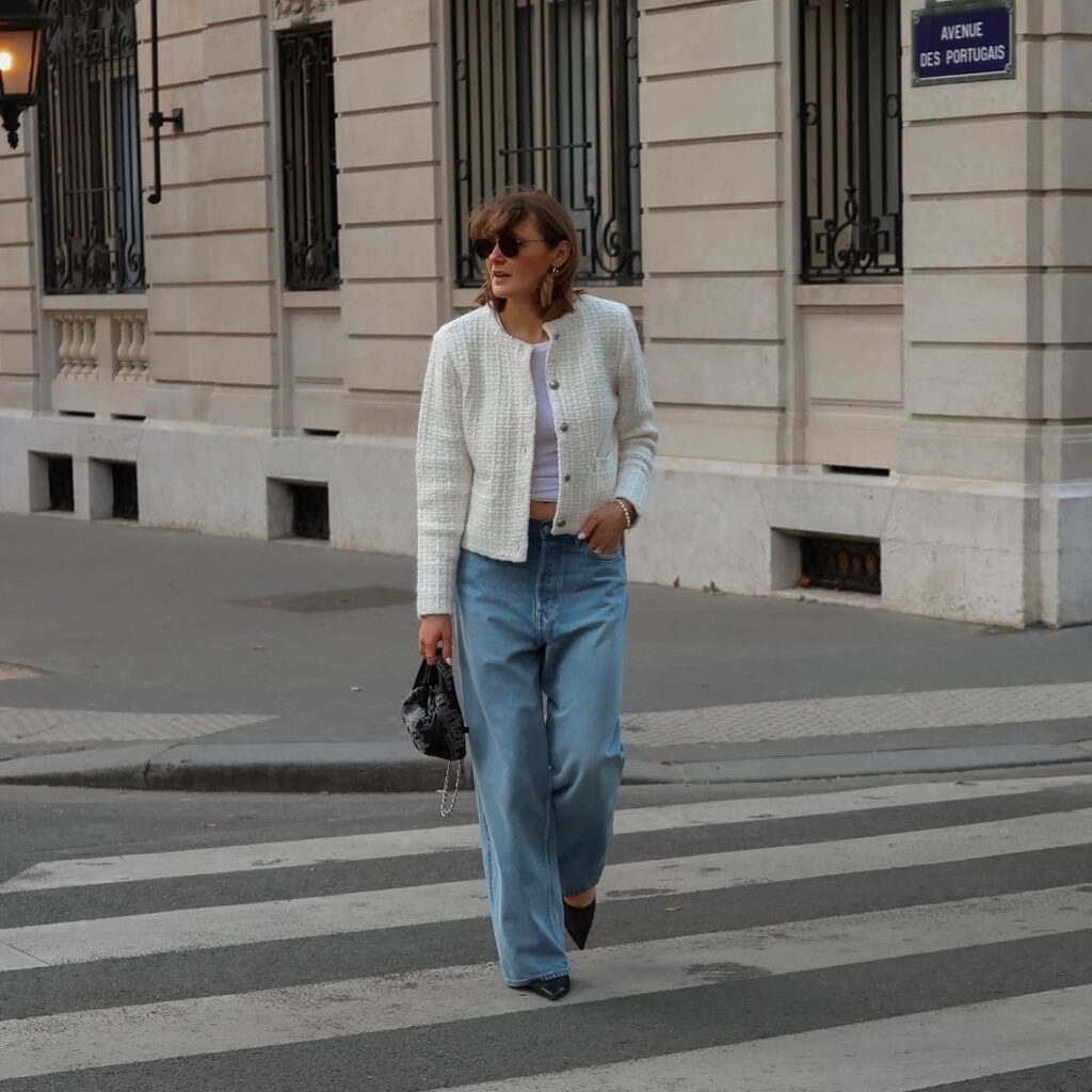 woman in baggy jeans, white tank top and cream-colored tweed jacket