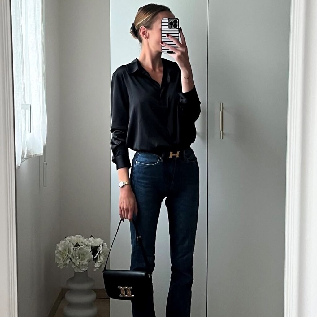 woman taking selfie in a black blouse and jeans