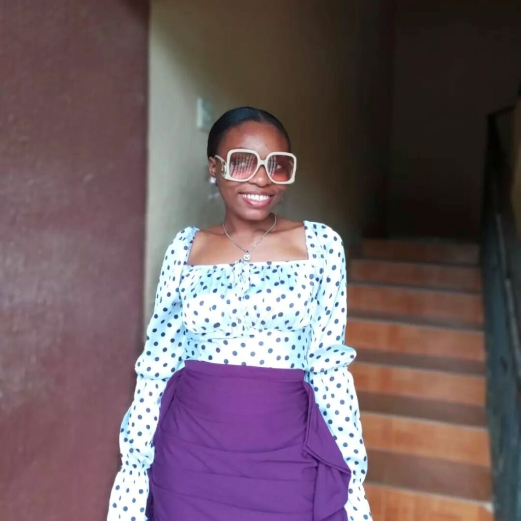 woman in polka dot silk top with purple skirt