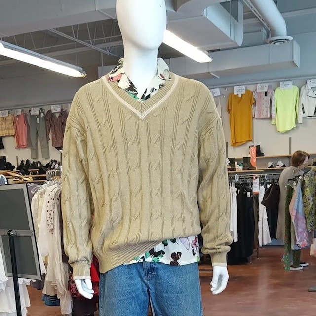 a mannequin wearing a tan sweater and jeans