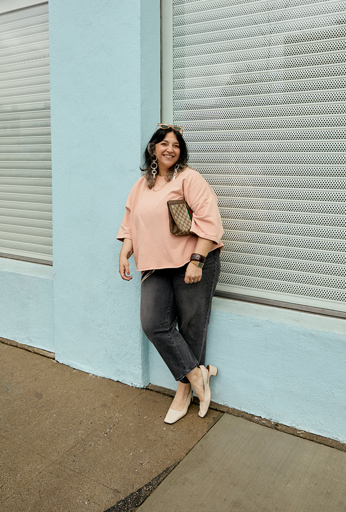 Kendra wearing a pink top, grey denim and cream colored block heeled sling back shoes