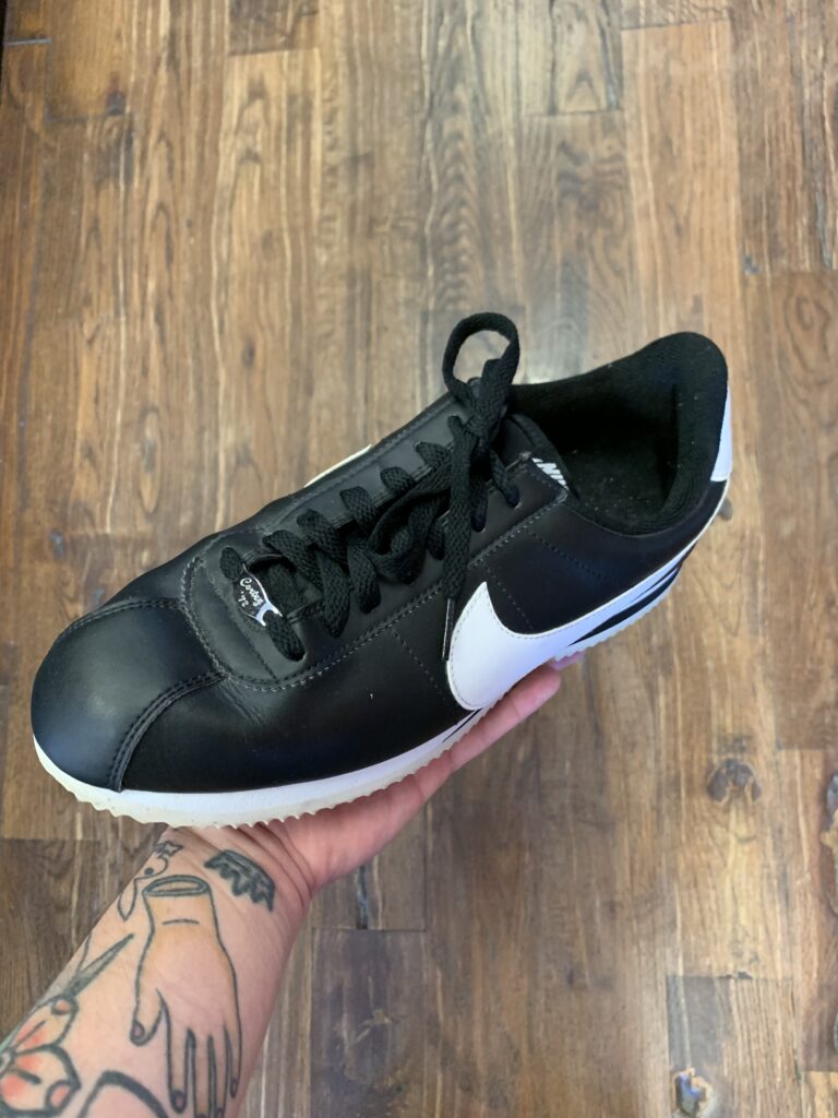 pair of low profile black sneakers with white swoop