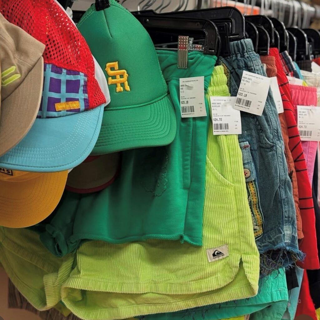 rack of baseball caps and shorts