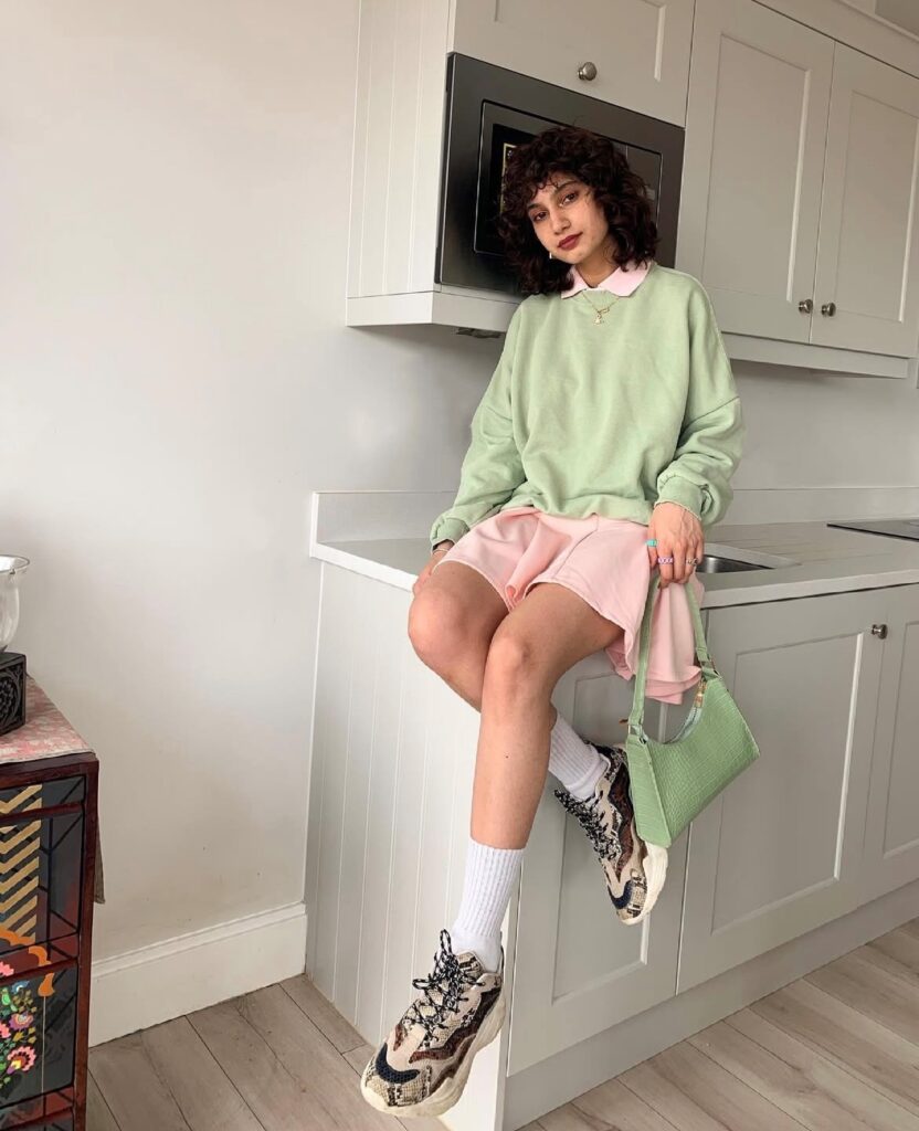 woman in mint green sweatshirt and pink skirt