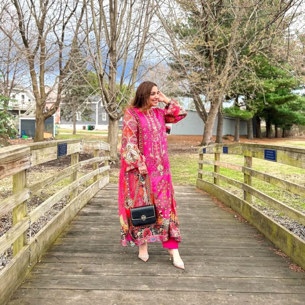 woman in bold pink floral tunic
