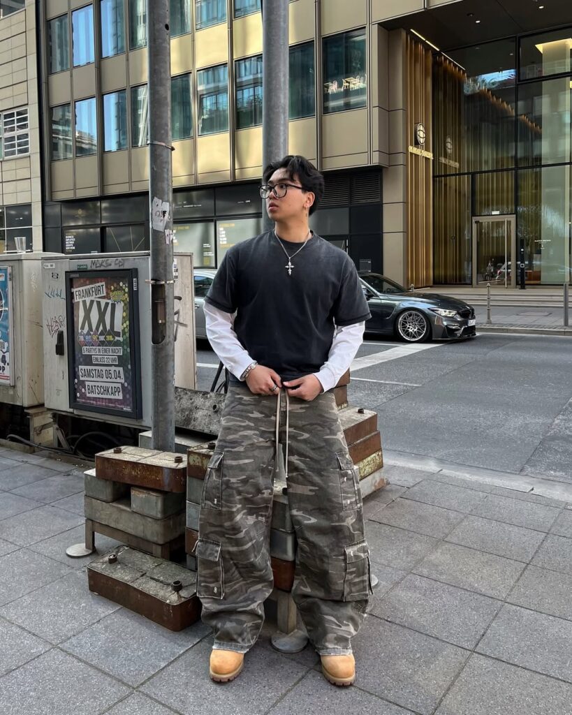 man in camo print oversized pants and black t-shirt