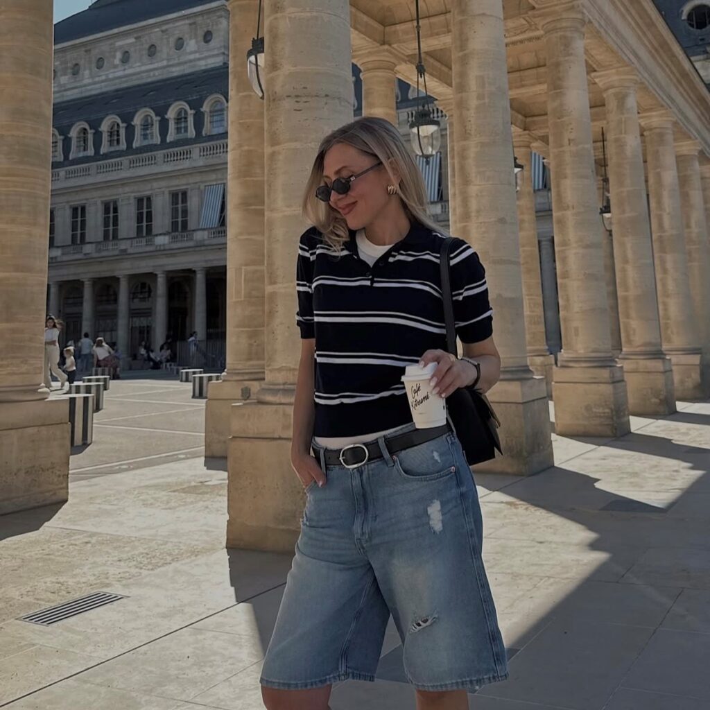 woman in a striped navy polo shirt and long denim shorts