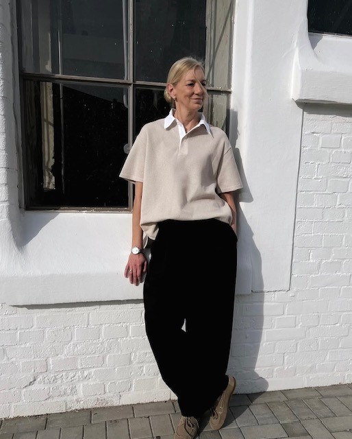 woman in polo style sweater and black pants