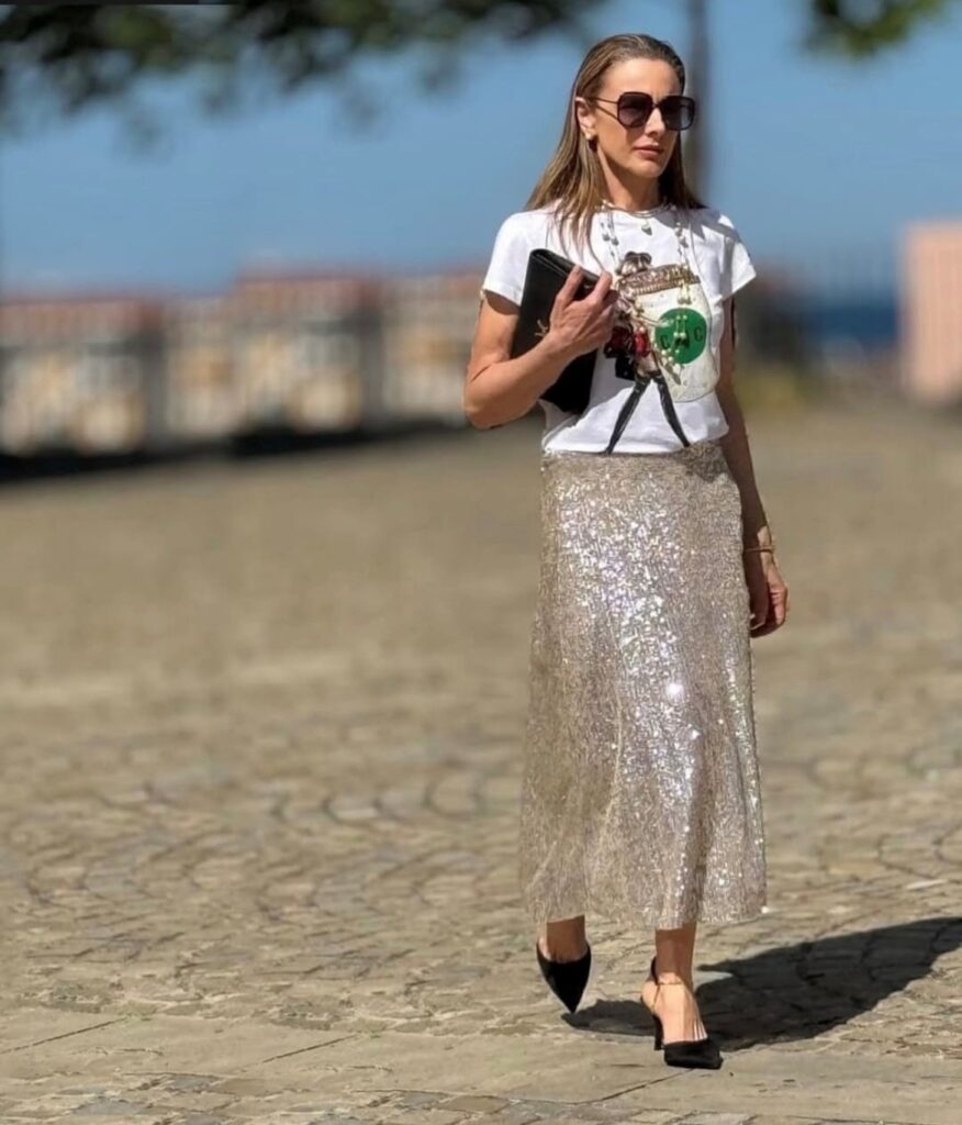 woman wearing a tee with long champagne colored sequin skirt and black heels