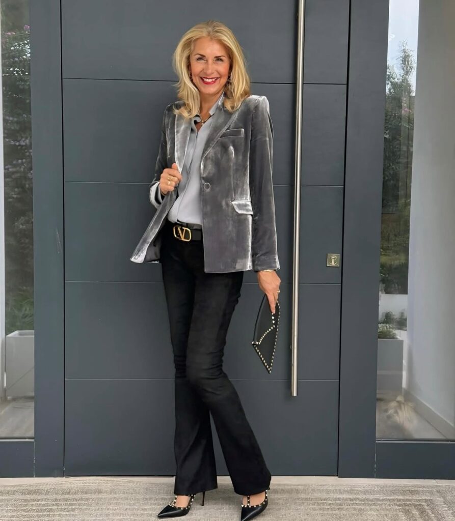 woman wearing a gray velvet blazer with gray silk blouse and black pants