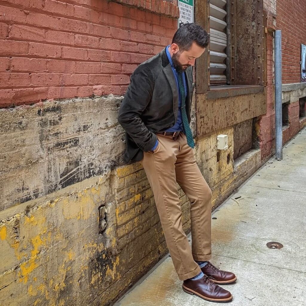 man in olive green blazer with khakis and blue button-up shirt