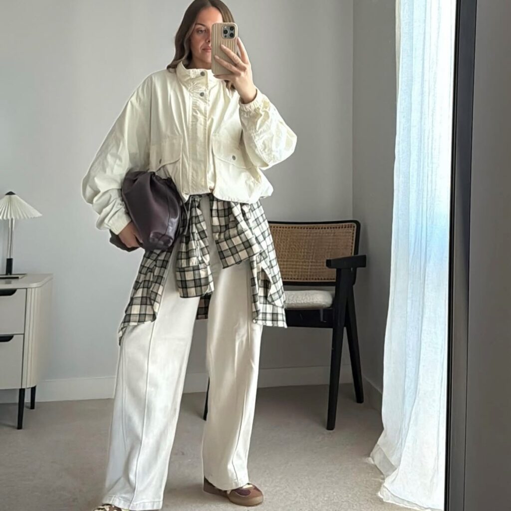 funnel neck jacket woman taking selfie in mirror with winter white funnel neck jacket and pants
