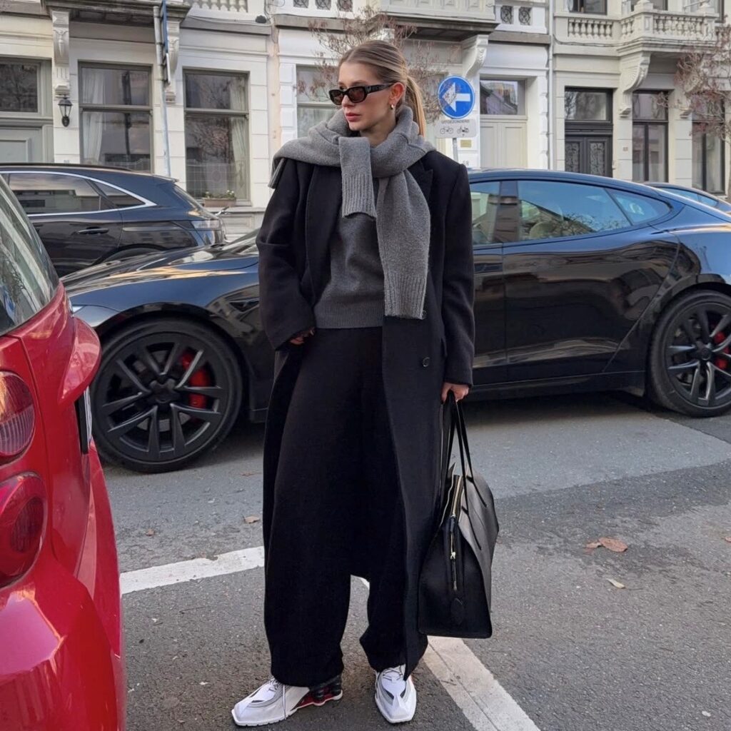 woman in coat, trousers, and sweatshirt with running shoes