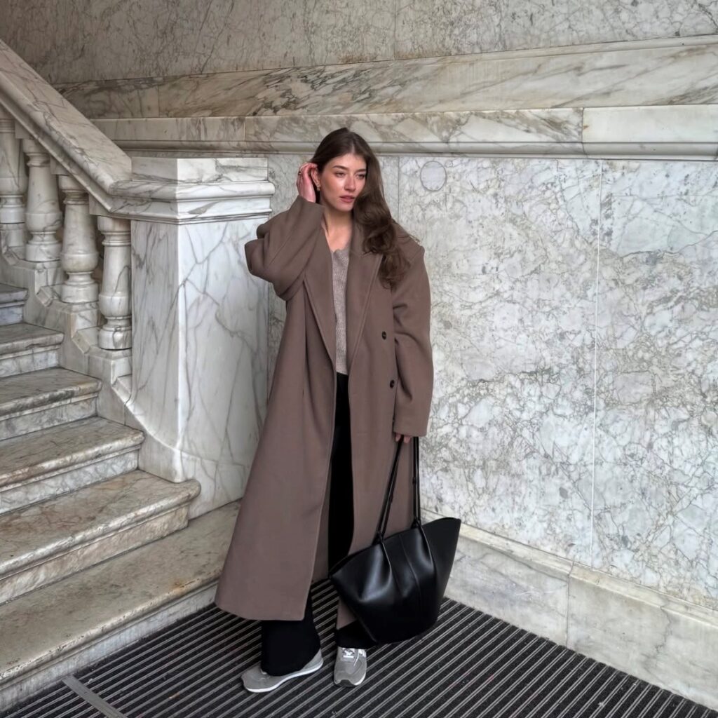 woman in coat with sweater and trousers