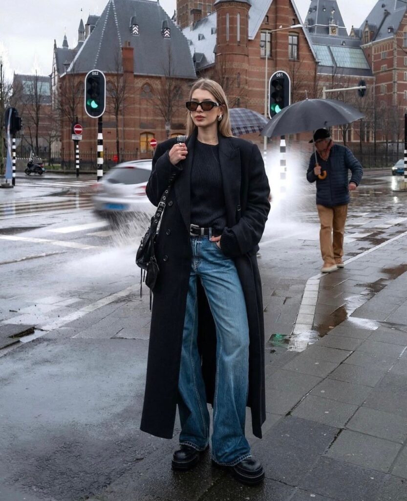 woman in oversized coat, jeans, and platform shoes