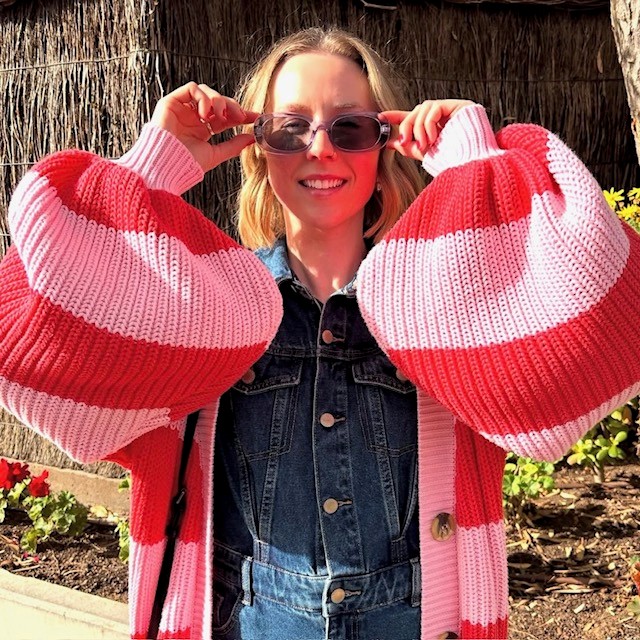 woman in balloon sleeve cardigan with pink and red stripes