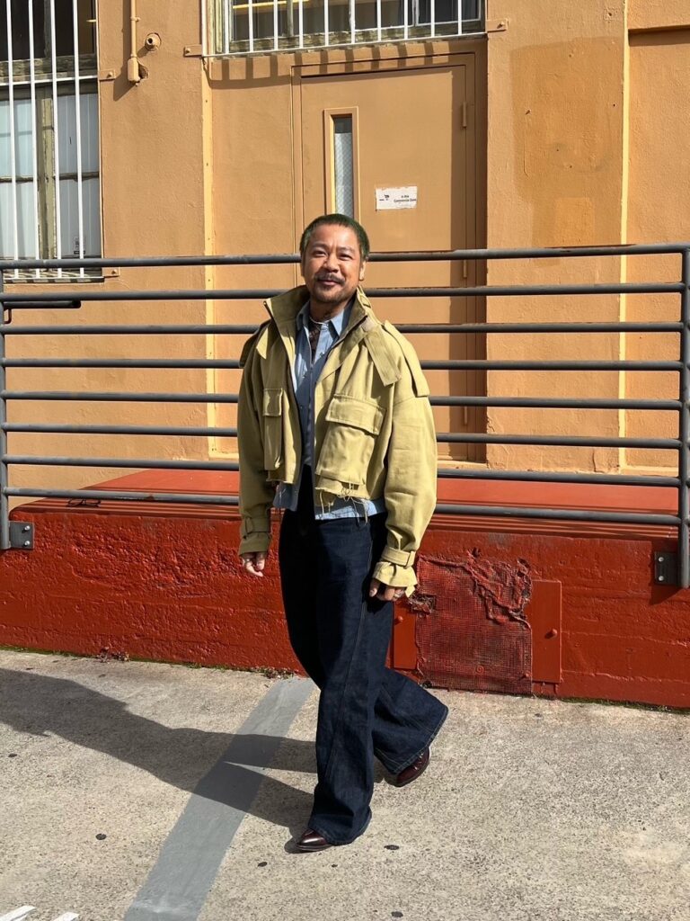 Arnel in jeans, ankle boots, and loose aviator jacket