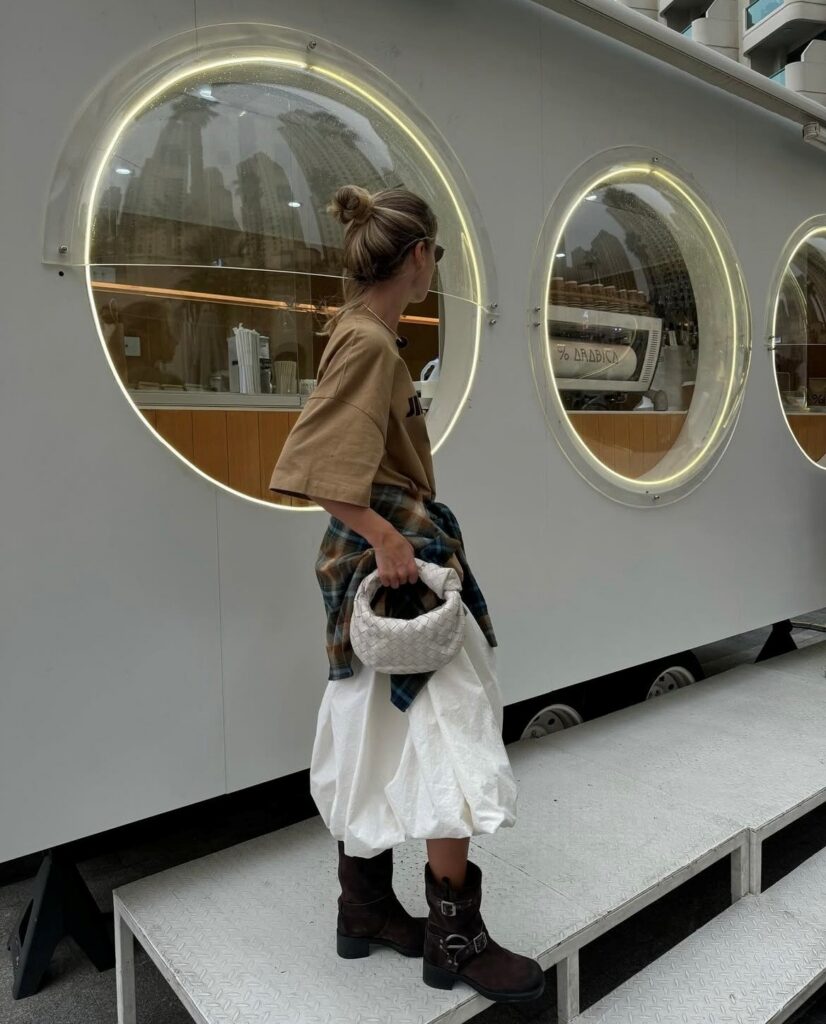 woman in white bubble skirt, tab tee, and black moto boots