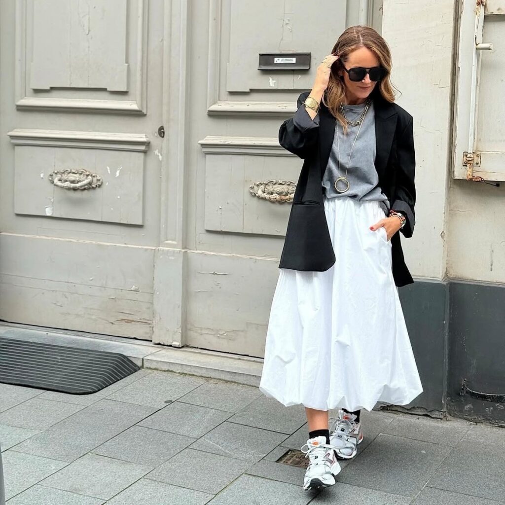 woman in white bubble skirt with gray tee and black blazer