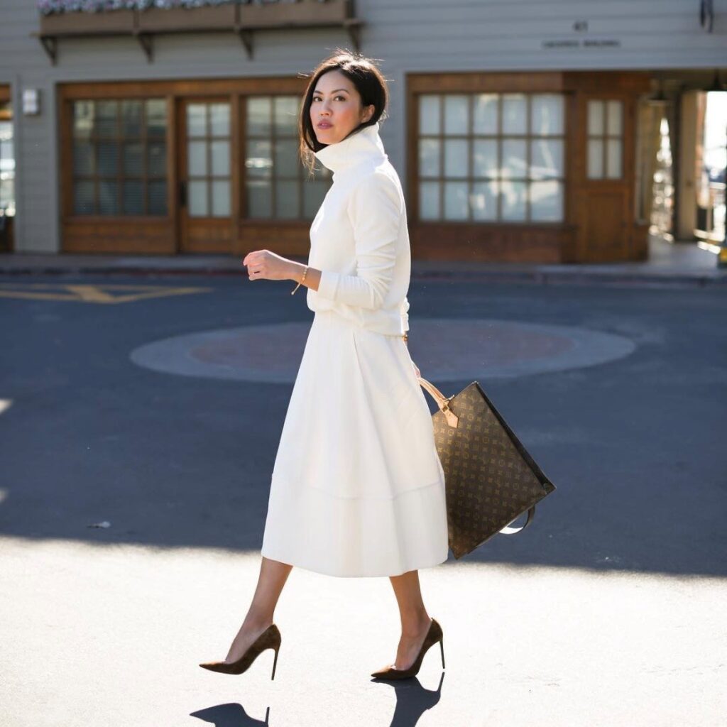 woman in ivory-colored turtleneck sweater and midi skirt