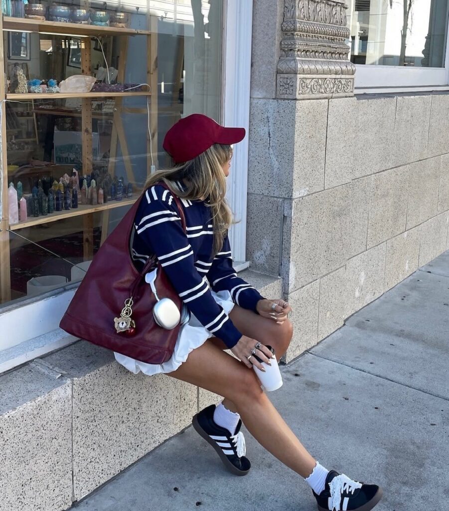woman in rugby sweater with white mini and sneakers