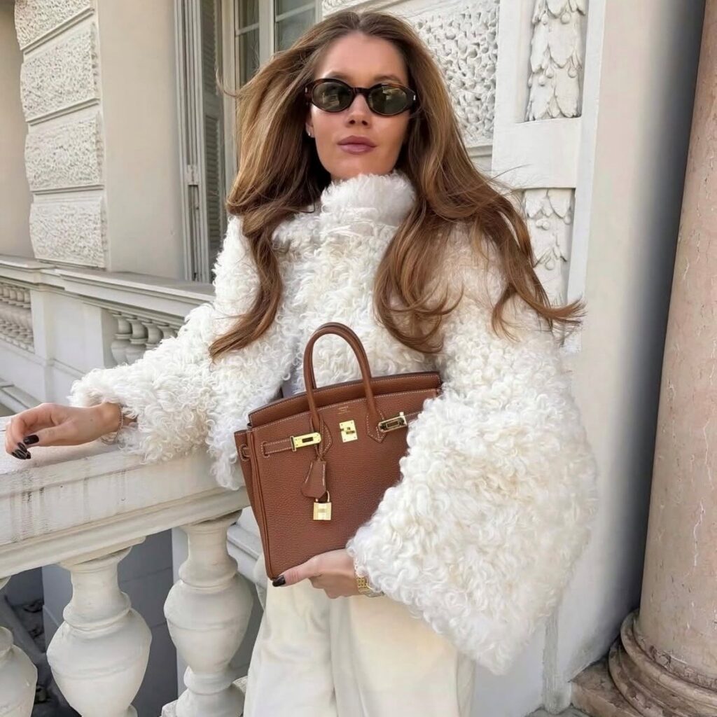 woman in furry jacket in cloud dancer color