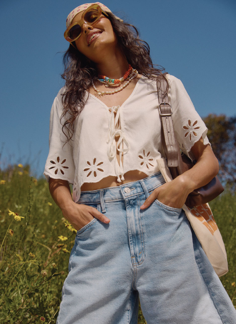 female model wearing a white linen tie front top and blue jorts