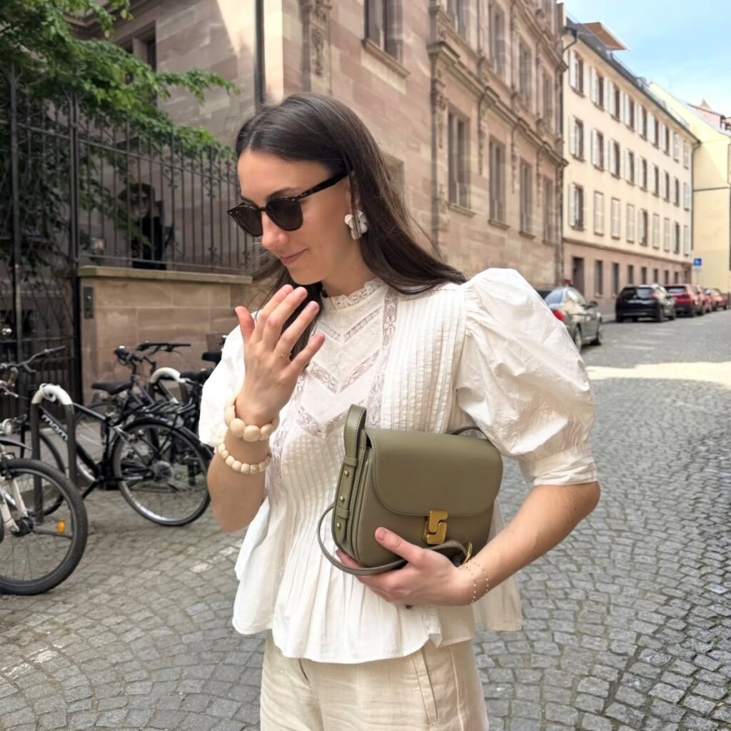 woman in white eyelet blouse with tan linen pants