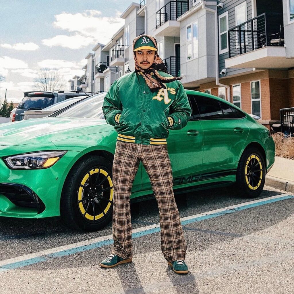 Man in plaid pants and green athletic jacket