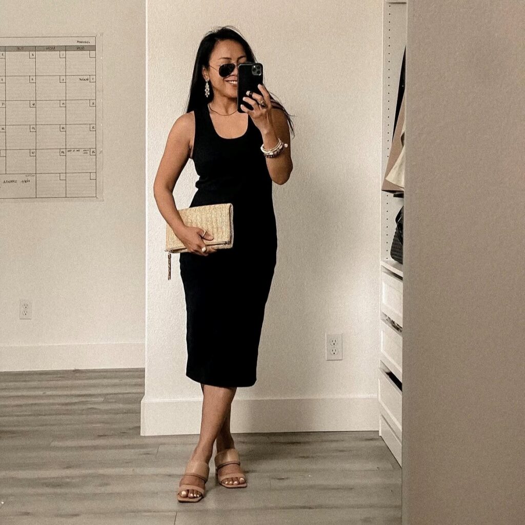 woman in black tank dress with sandals and clutch
