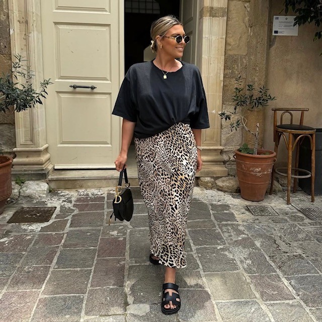 woman in boxy black tee with leopard print skirt