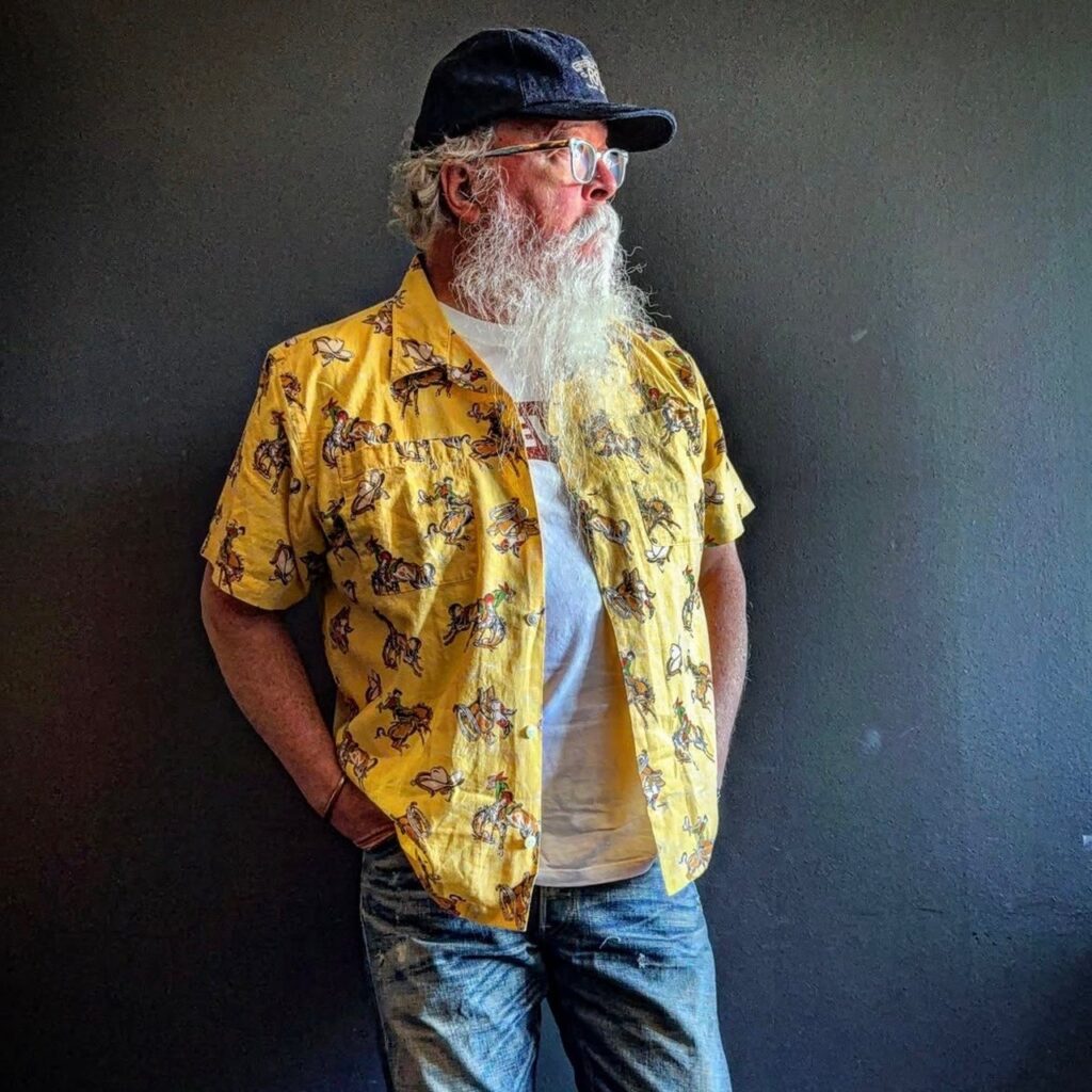 man wearing a yellow cowboy-print camp shirt