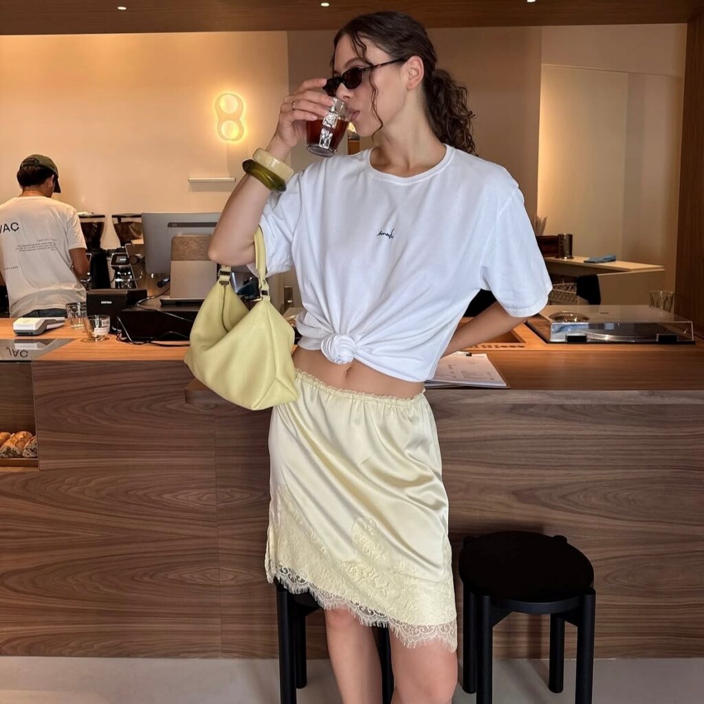 woman wearing short yellow slip skirt with white tee